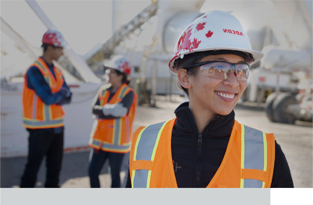 Man wearing a hard hat and a surgical mask on a construction site.